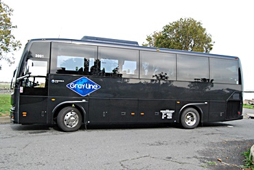 large 30 passenger bus that is black with the Gray Line logo on the side that is ready for a Napa Valley tour