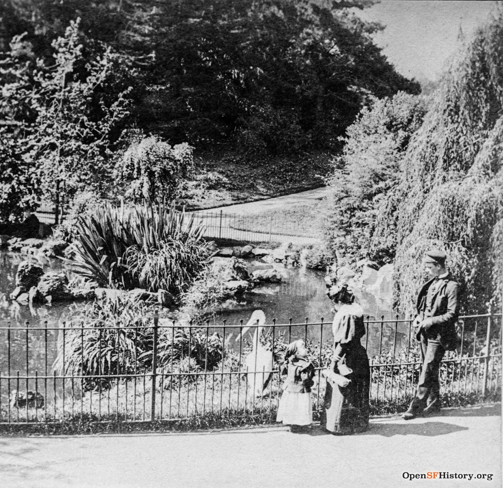 1880's photo of golden gate park when it was created by the silver rush investors. the image shows a family looking at a pong that has a bird in it