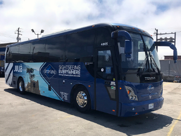 large 40 passenger bus that is dark blue with the Gray Line logo on the side that is ready for a Muir Woods Tour