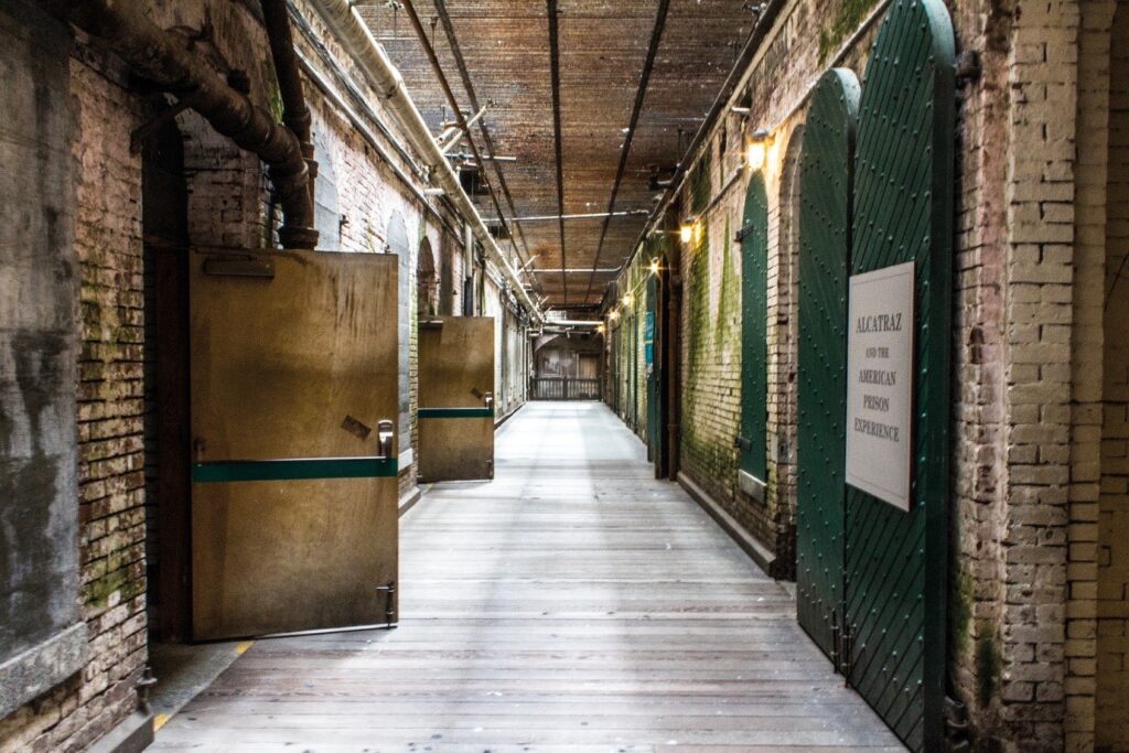 hallway in alcatraz prison with the old bricks and doors open