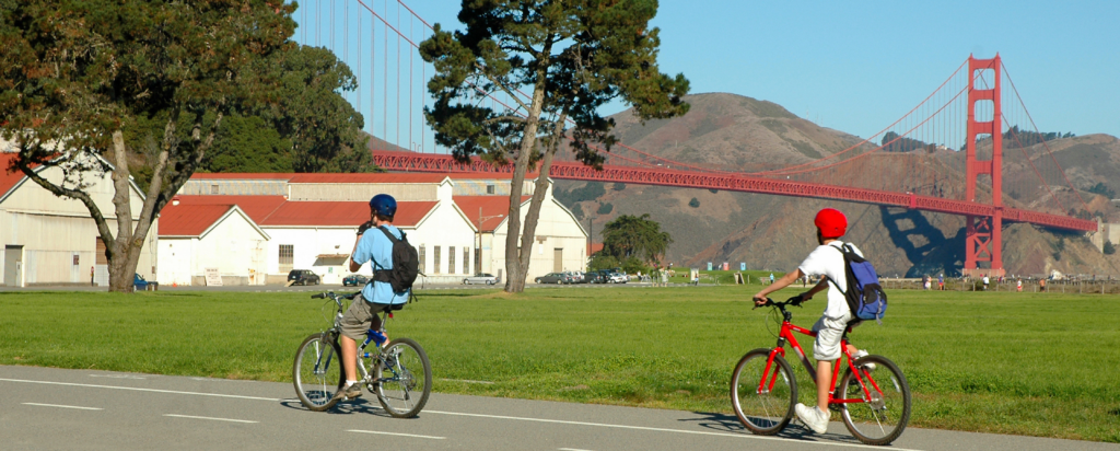 two guys biking in the presidio with the golden gate bridge in the background